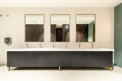 Solid Surface Vanity Troughs mounted onto bespoke framing, faced with real wood veneer ribbed apron under panelling, stained to match